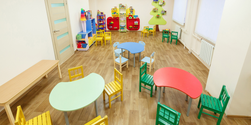 A spacious game room with colorful tables for classes in the kindergarten.